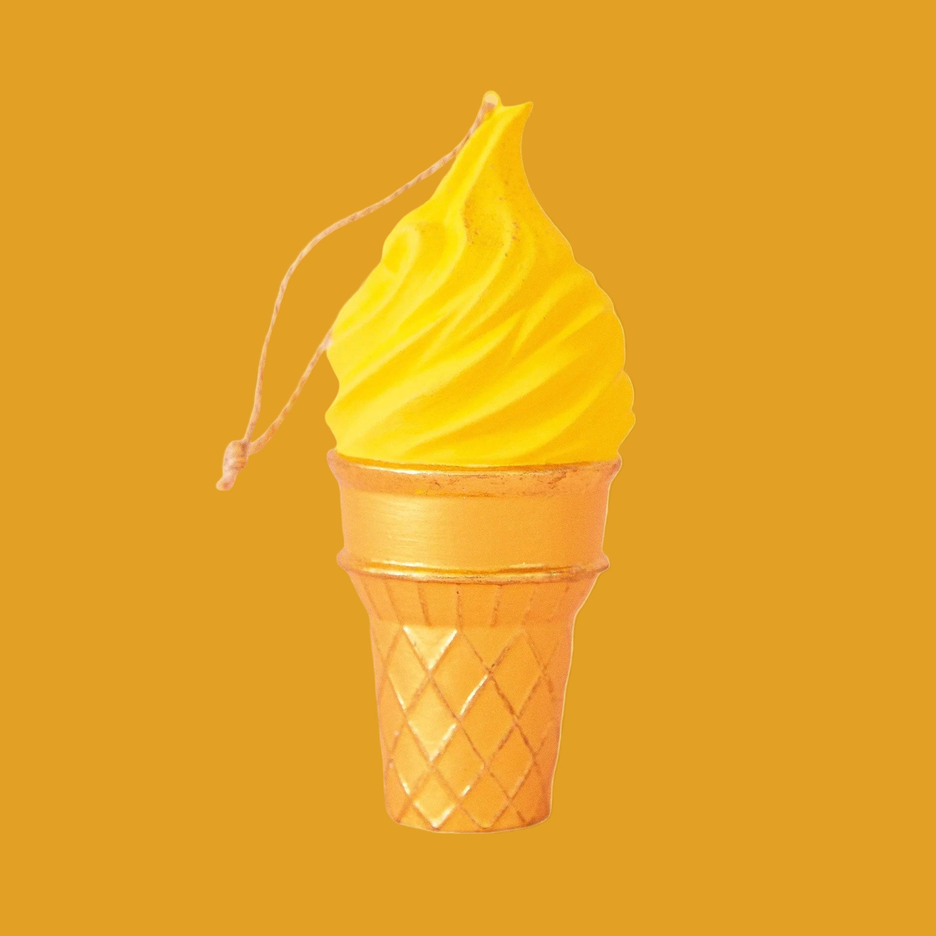 On a golden background is a yellow ice cream cone shaped ornament. 
