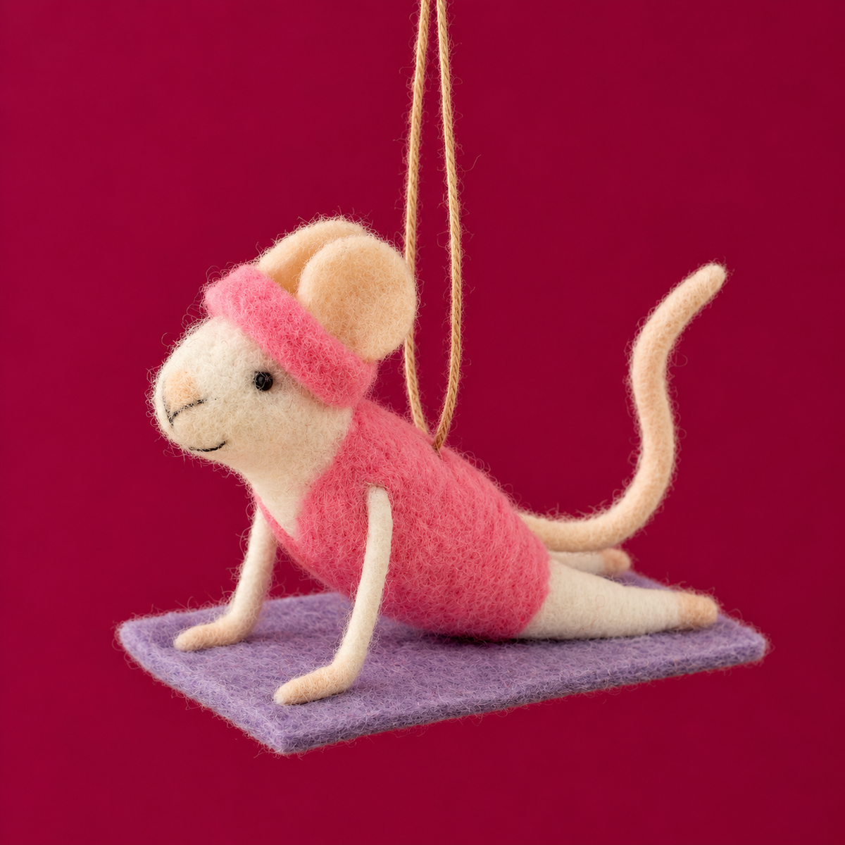 a mouse shaped felt ornament doing yoga