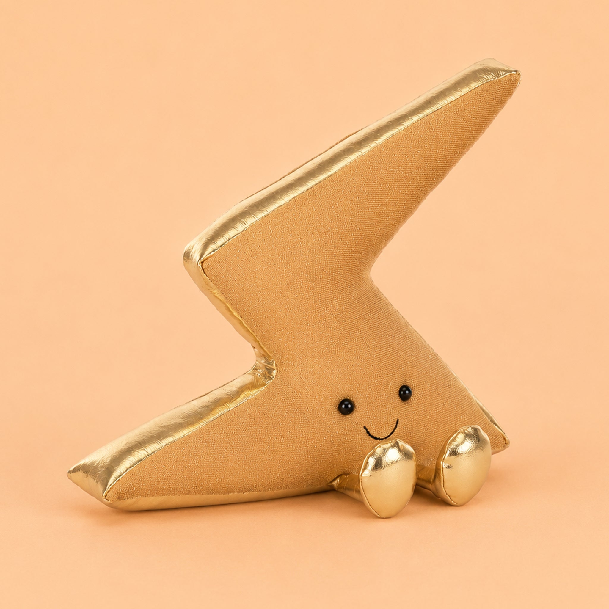 A gold lightning bolt shaped stuffed plush toy. 