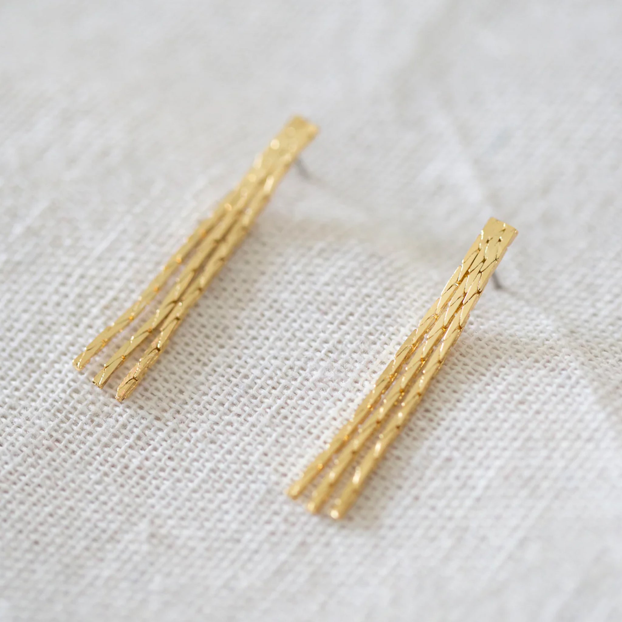 A pair of dangle gold earrings. 