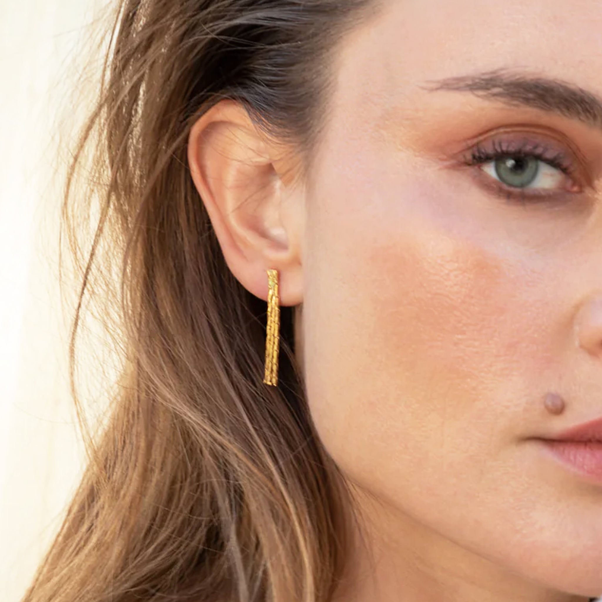 A pair of dangle gold earrings. 
