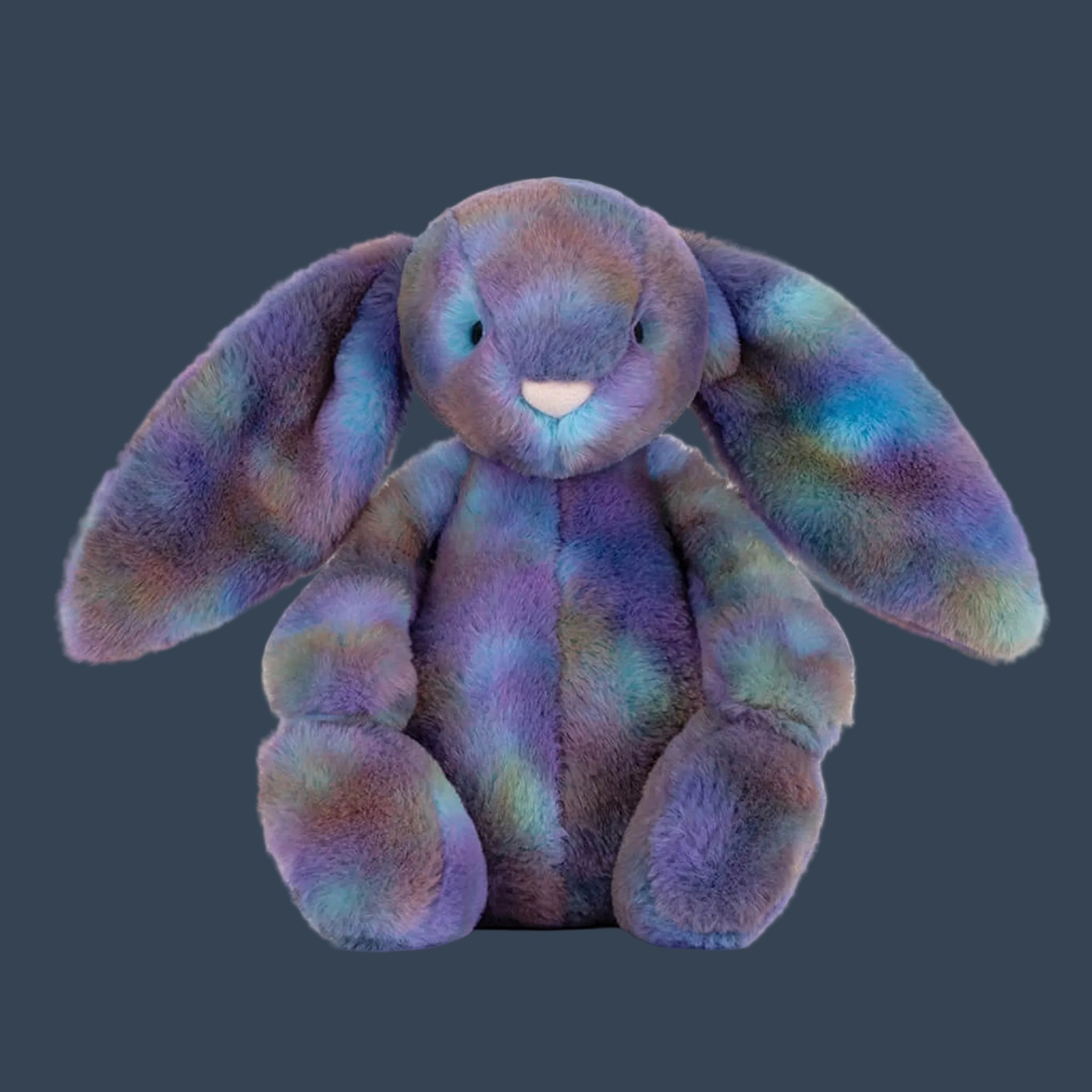 A muti colored, purple, blue and green bunny shaped stuffed animal. 