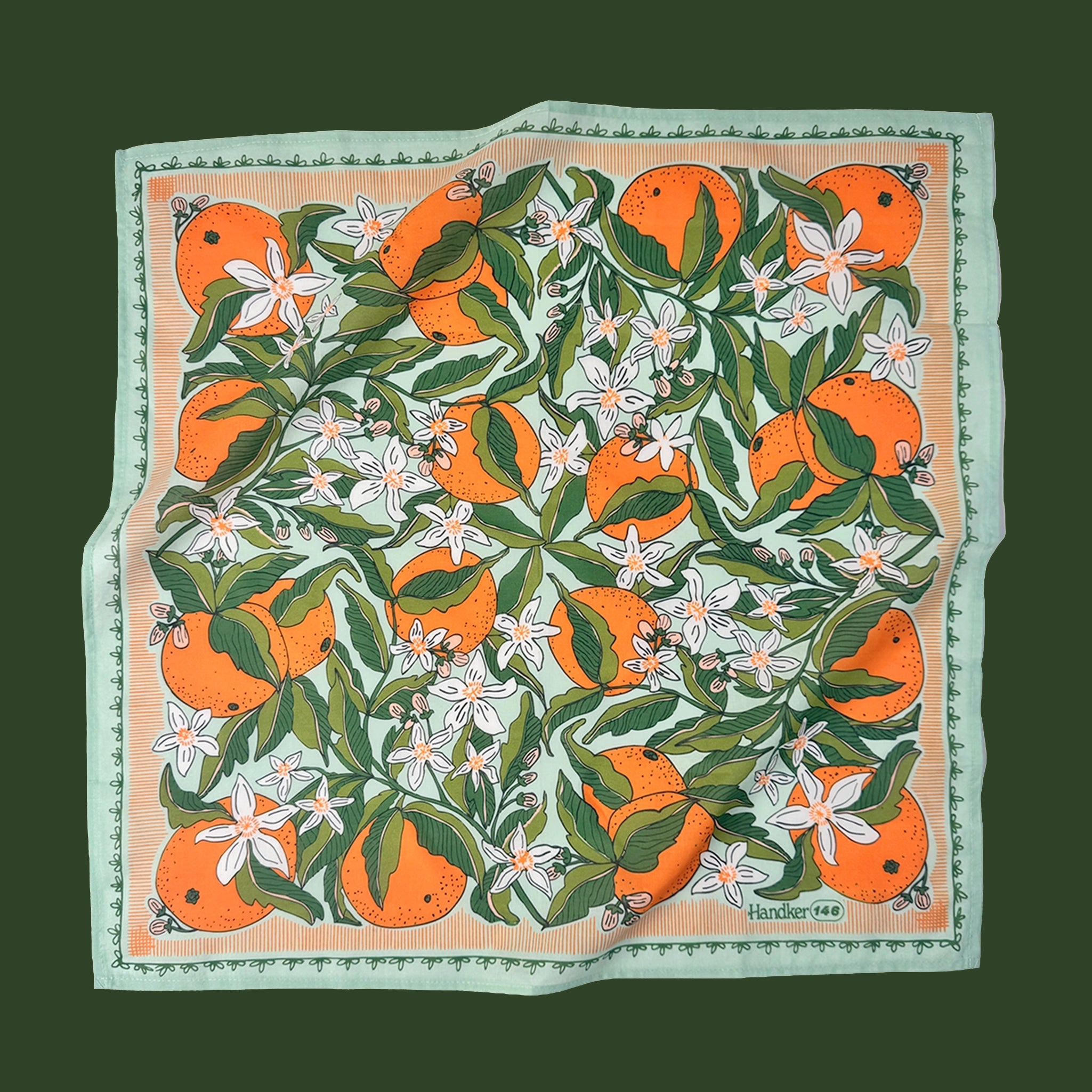 Orange blossom bandana featuring a repeating citrus and leaf pattern in bright orange and green with a soft mint border.
