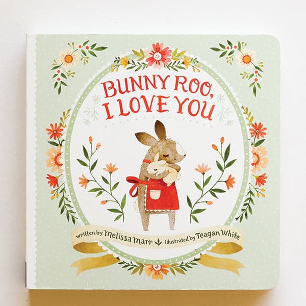 A light green book cover with various flowers illustrations and a graphic of a bunny holding a smaller bunny and hugging it along with the title in red font that reads, "Bunny Too, I Love You".