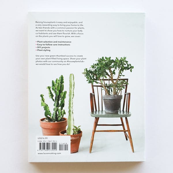On a white background is the backside of the book that features a photograph of house plants and cacti in pots. 