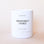 On a cream background is a white candle with black text that reads, "Makana Grapefruit Lychee 100% Soy Wax Candle". 