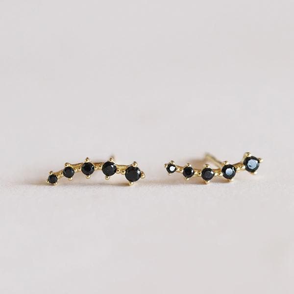 Gold earring crawlers with 5 black cubic zirconia stones that decrease in size towards the end of the earring along with a straight post. 