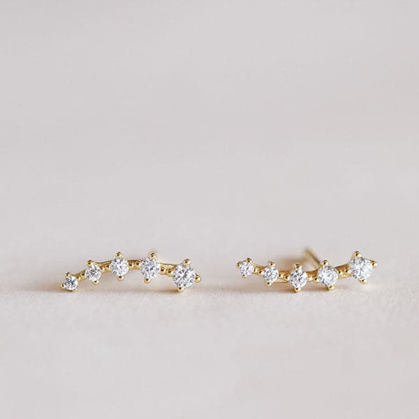 Pair of two, five-stone cascading crawlers feature white cubic zirconia placed in horizontal row and set in 18k gold-plated sterling silver.