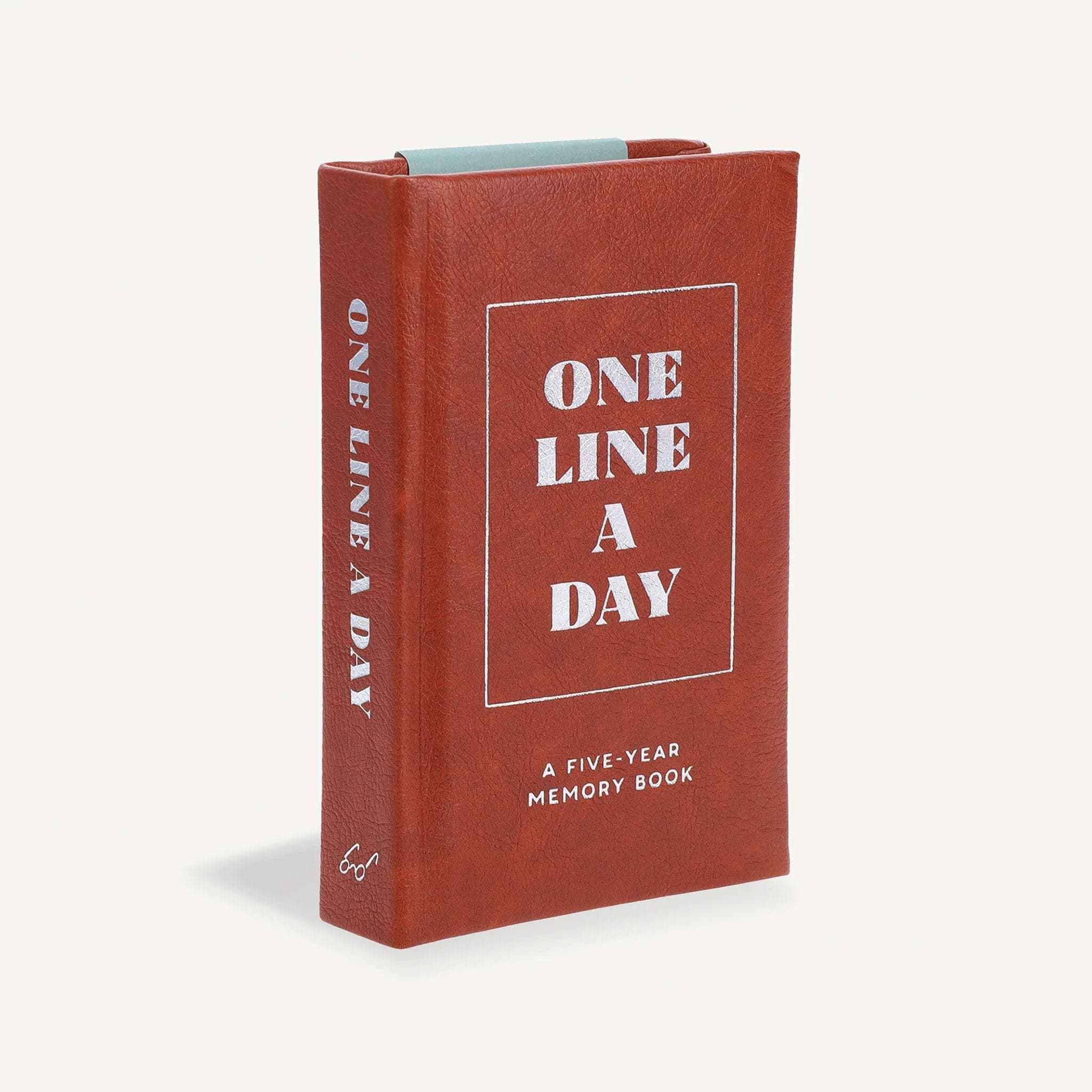 A brown vegan leather journal that says, "One Line A Day" on the front cover.