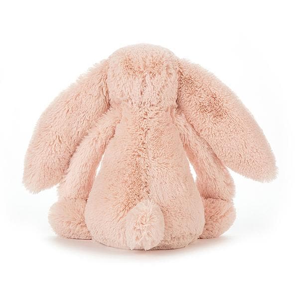 Soft stuffed animal in the shape of a pink blush colored rabbit with long floppy ears, arms and legs.