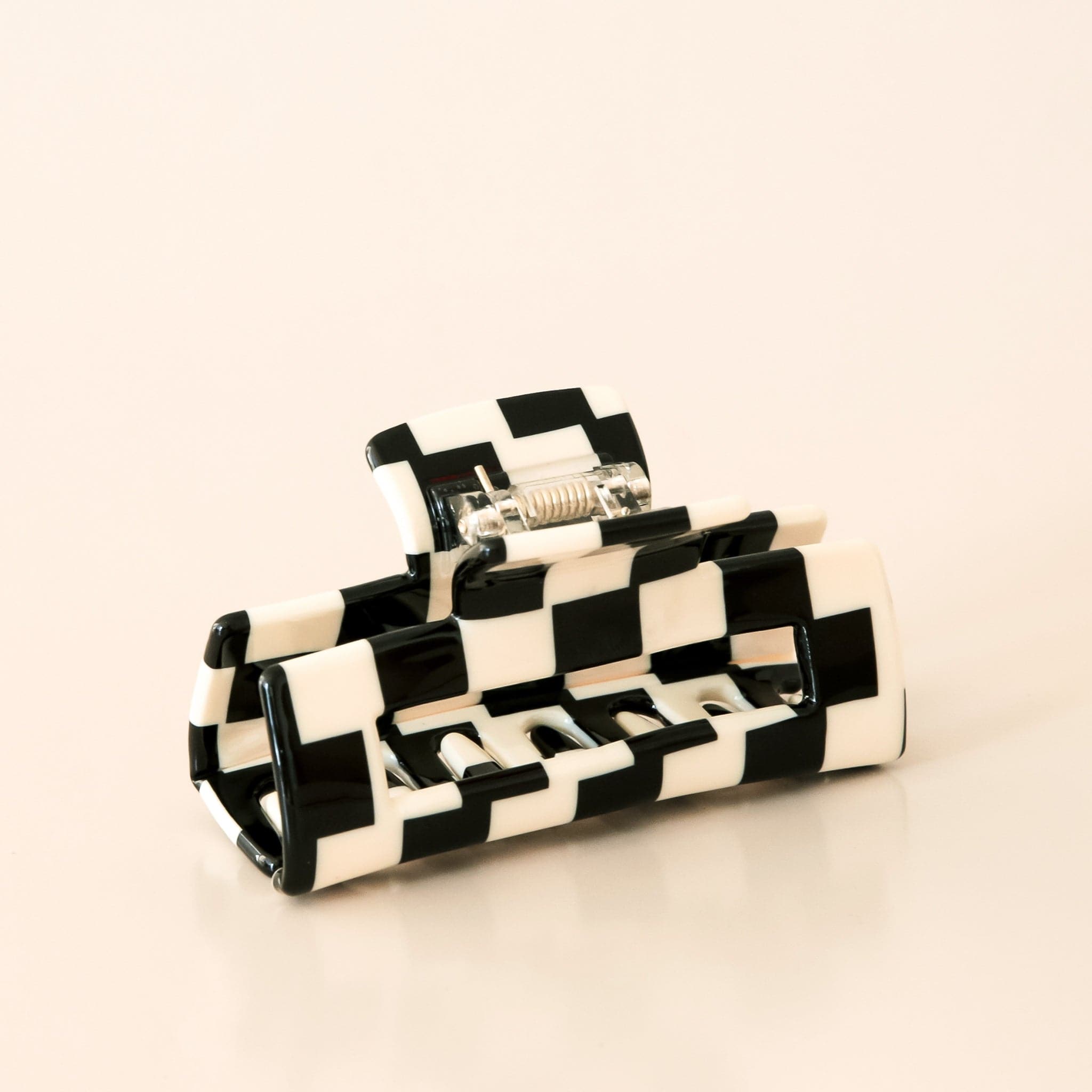 Large black and white checkered claw hair clip with a narrow rectangle shape and two simple geometric cutouts.