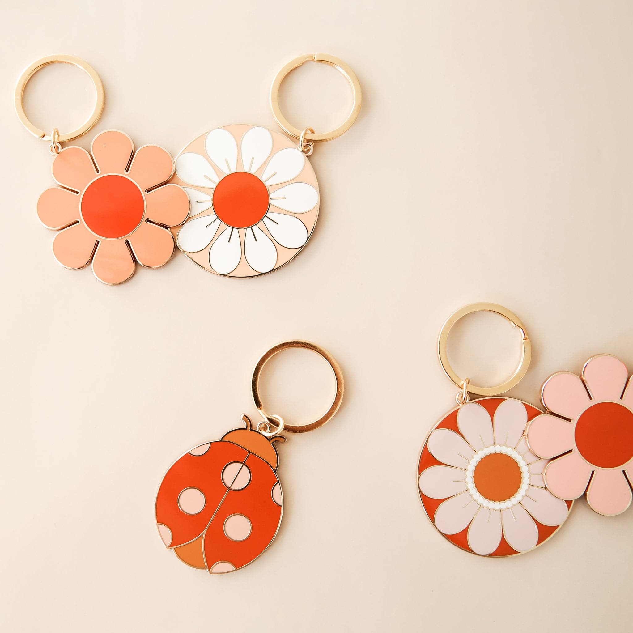 Five retro-inspired keychains including a variety of flowers and a ladybug. 