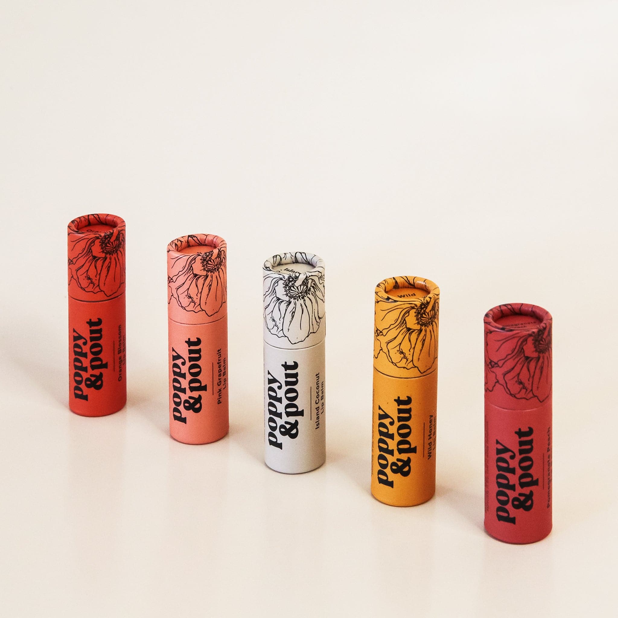 Standing in front of a white background is five tubes. Each tube has a black drawing of a black flower on the top end and black text on the bottom that reads ‘poppy &amp; pout.’ Starting from left the colors are bright orange red, peach, white, yellow and dark red. 