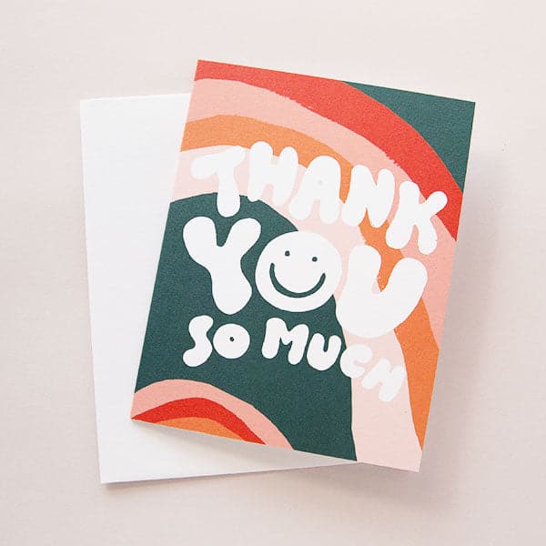 This groovy card reads 'Thank You So Much' in 70s inspired white bubble letters. The 'O' of 'You' is a white beaming smiley face. The background is filled with red, deep jade and peach abstract arches. 