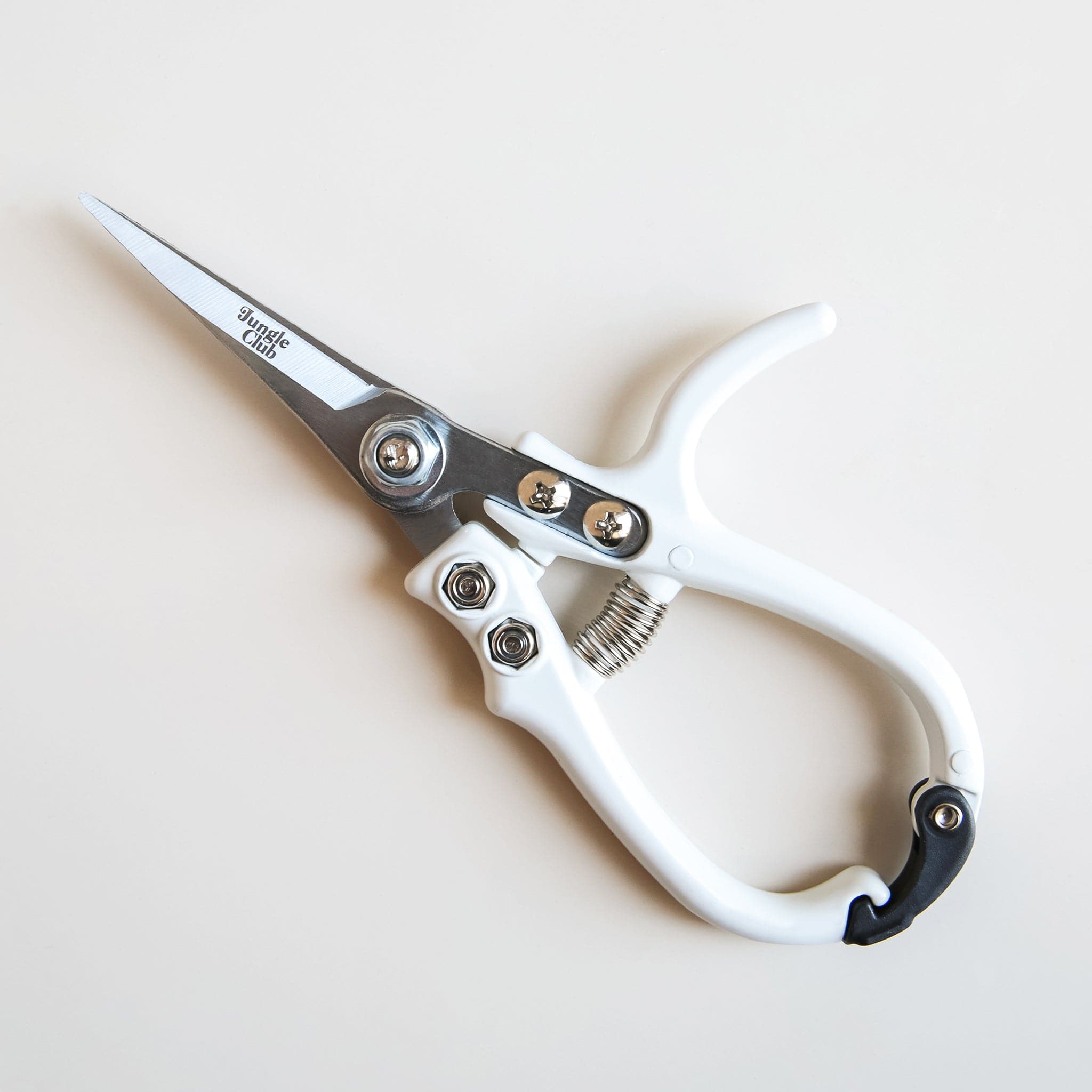 Pair of pruning shears with white handles and metal blades. The outer blade reads &#39;jungle club&#39; in small, playful lettering. The pruning shears have a black clasp at the top of the handles to secure them closed.