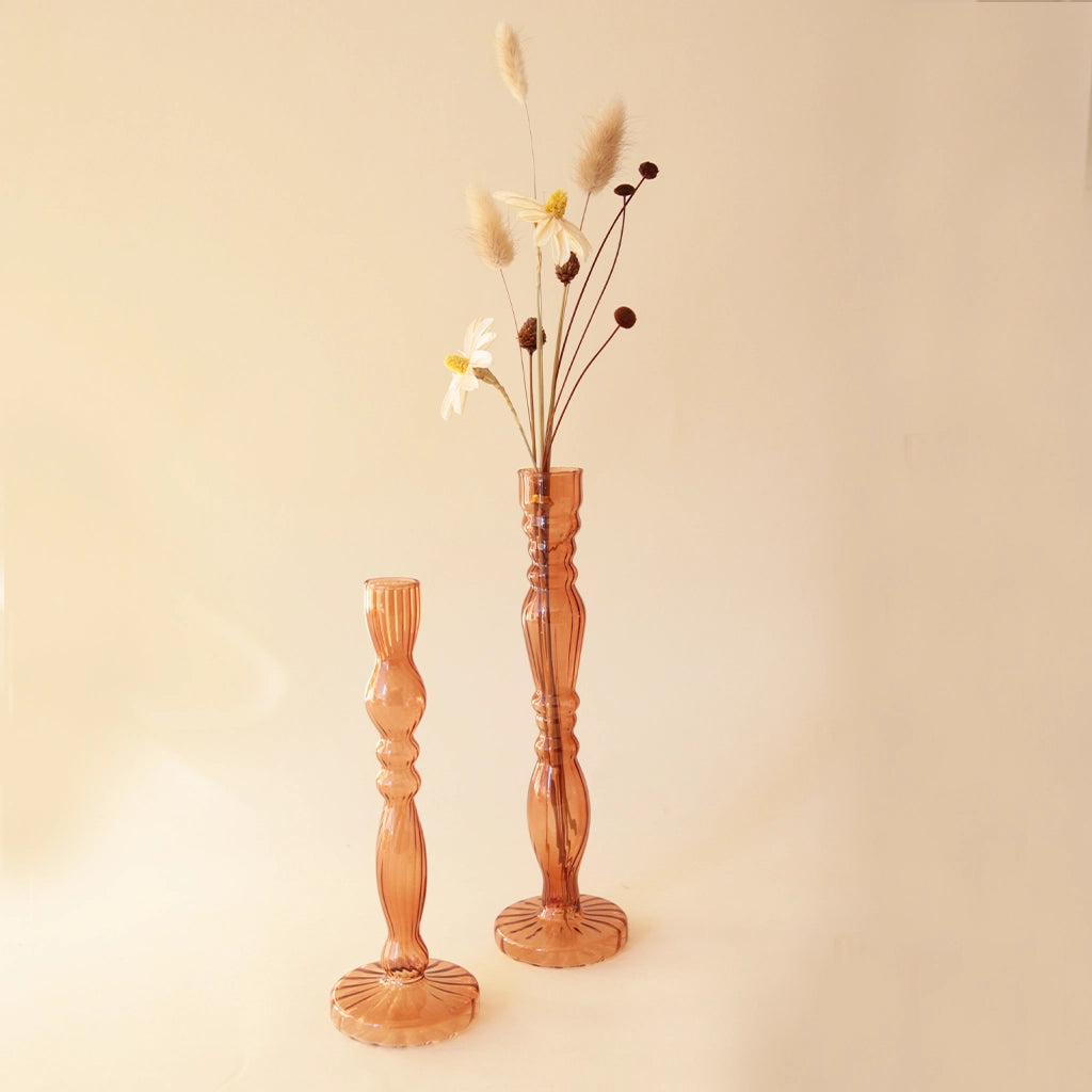 A thin glass bud vase with intricate details in an amber shade.