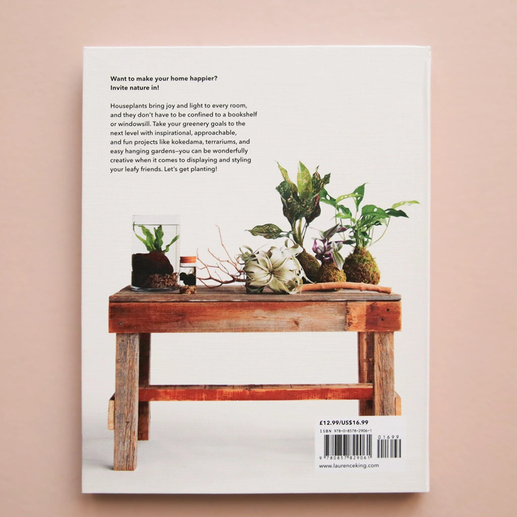 A white book with a green leafy plant and a title that reads, &quot;How to plant a room and grow a happy home.&quot;