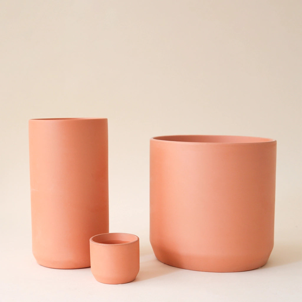 A terracotta ceramic vase with a simple cylinder design.