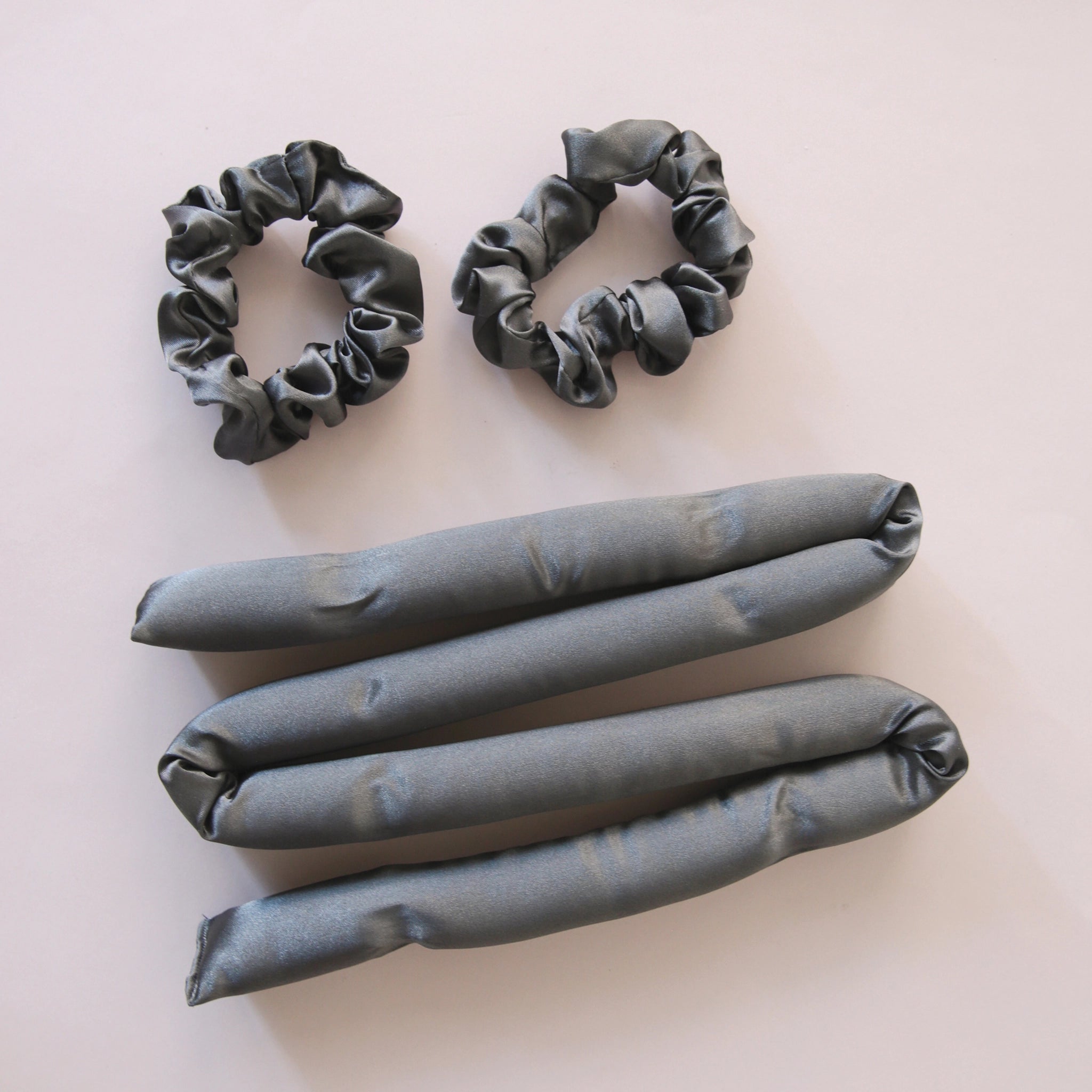 A black satin heatless curler with two included scrunchies.