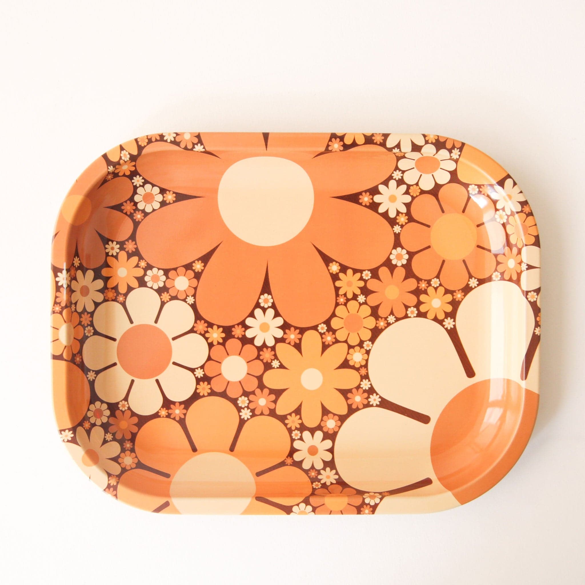 A metal tray perfect for rolling or all your favorite trinkets. It features a 70&#39;s inspired floral design with a variation of daisies in different shapes, sizes and colors.