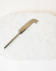  On a white background is a white marble cheese board with a cutting knife and a silver edge.
