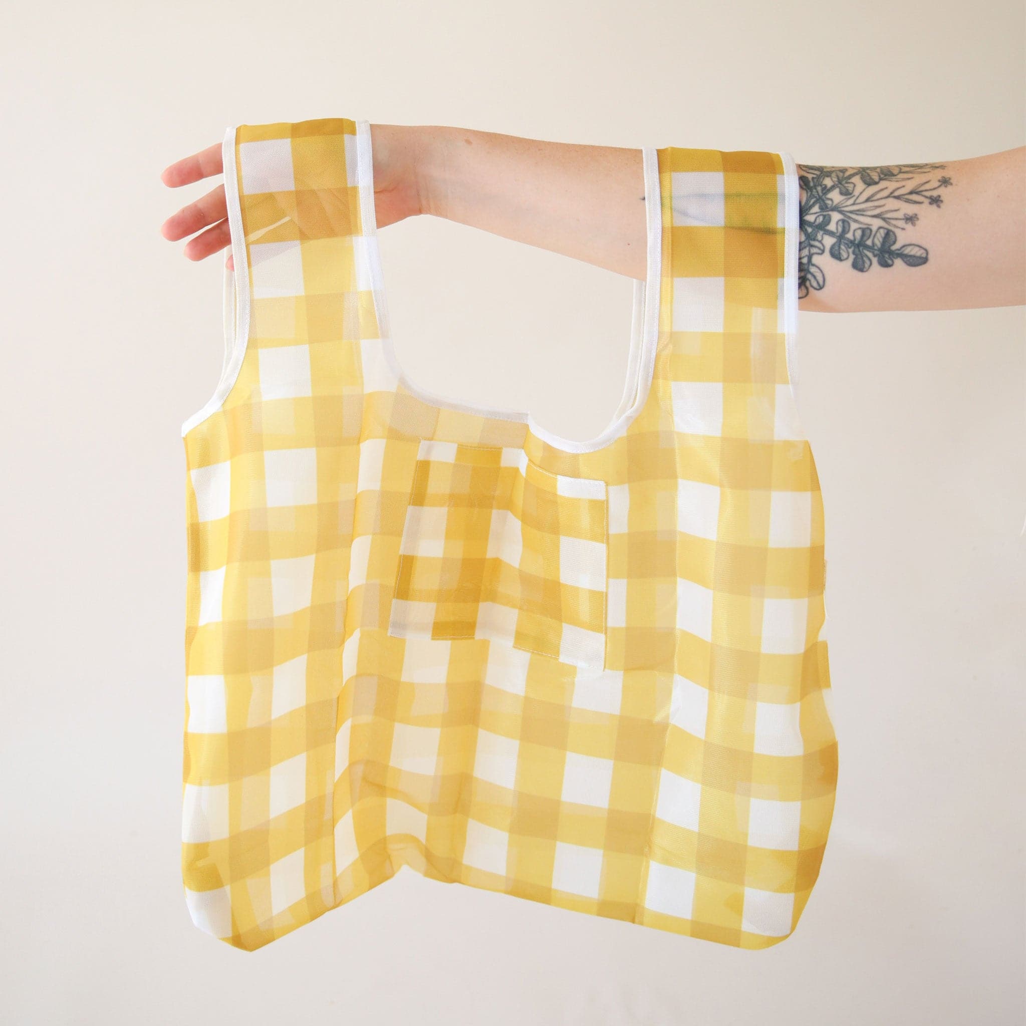 A yellow gingham nylon bag with two straps and a small pocket for keys or easy-to-grab essentials.