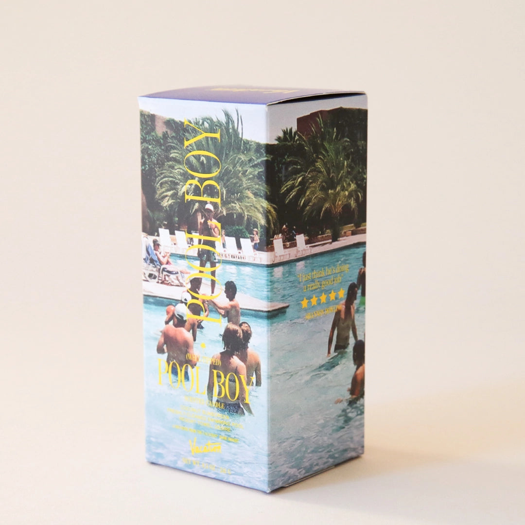 The exterior of the candle packaging that features an all over pool print with people swimming along with text that reads, "Pool Boy" in yellow text.