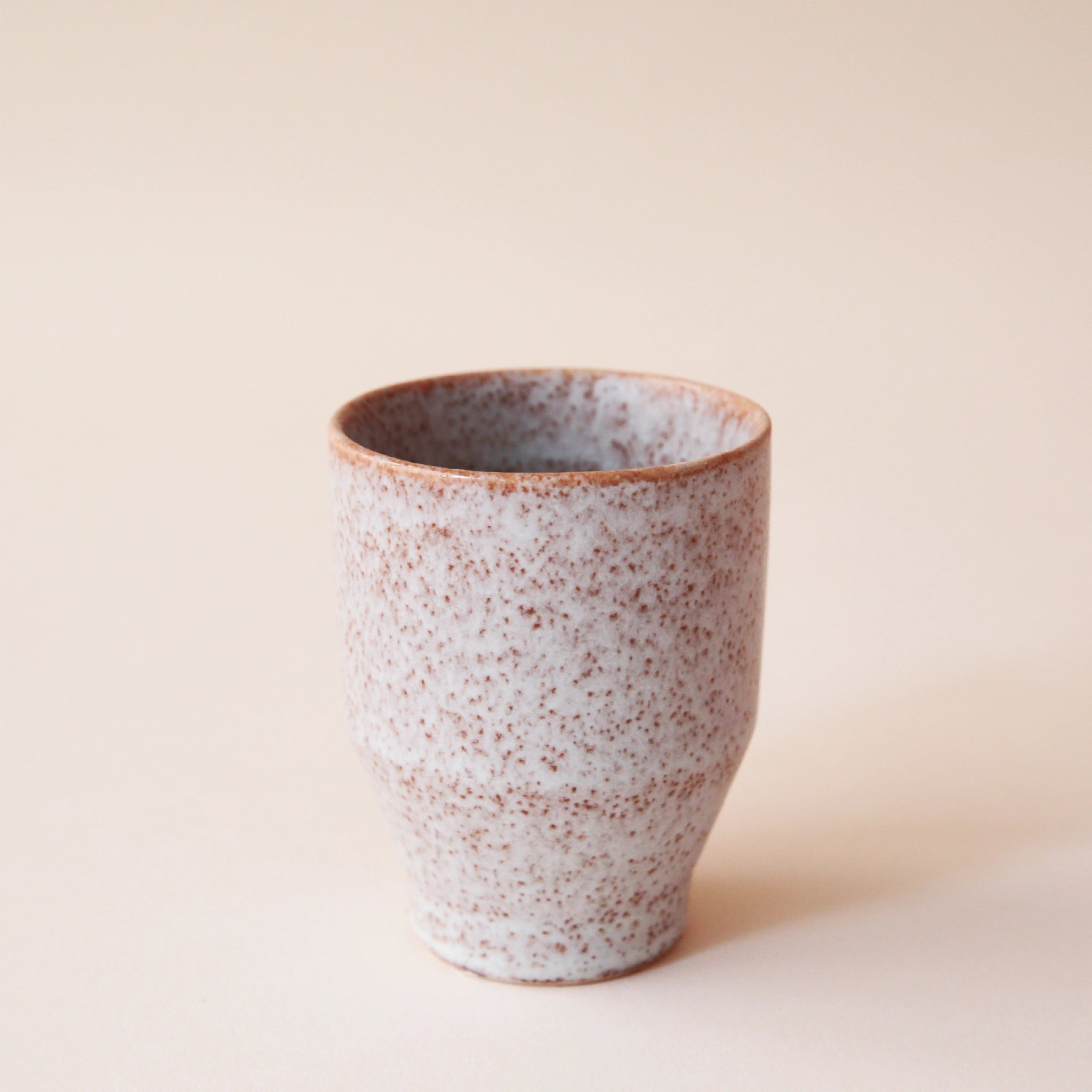 A classic ceramic planter with a speckled white and tan texture.