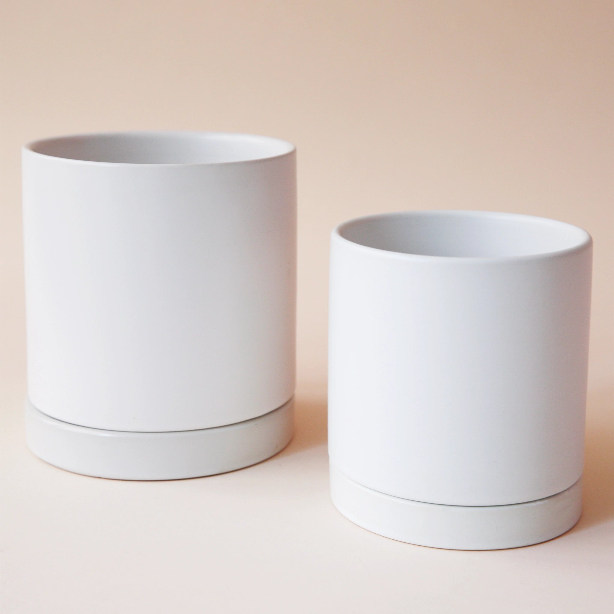 two simple white cylindrical pots with matching saucer