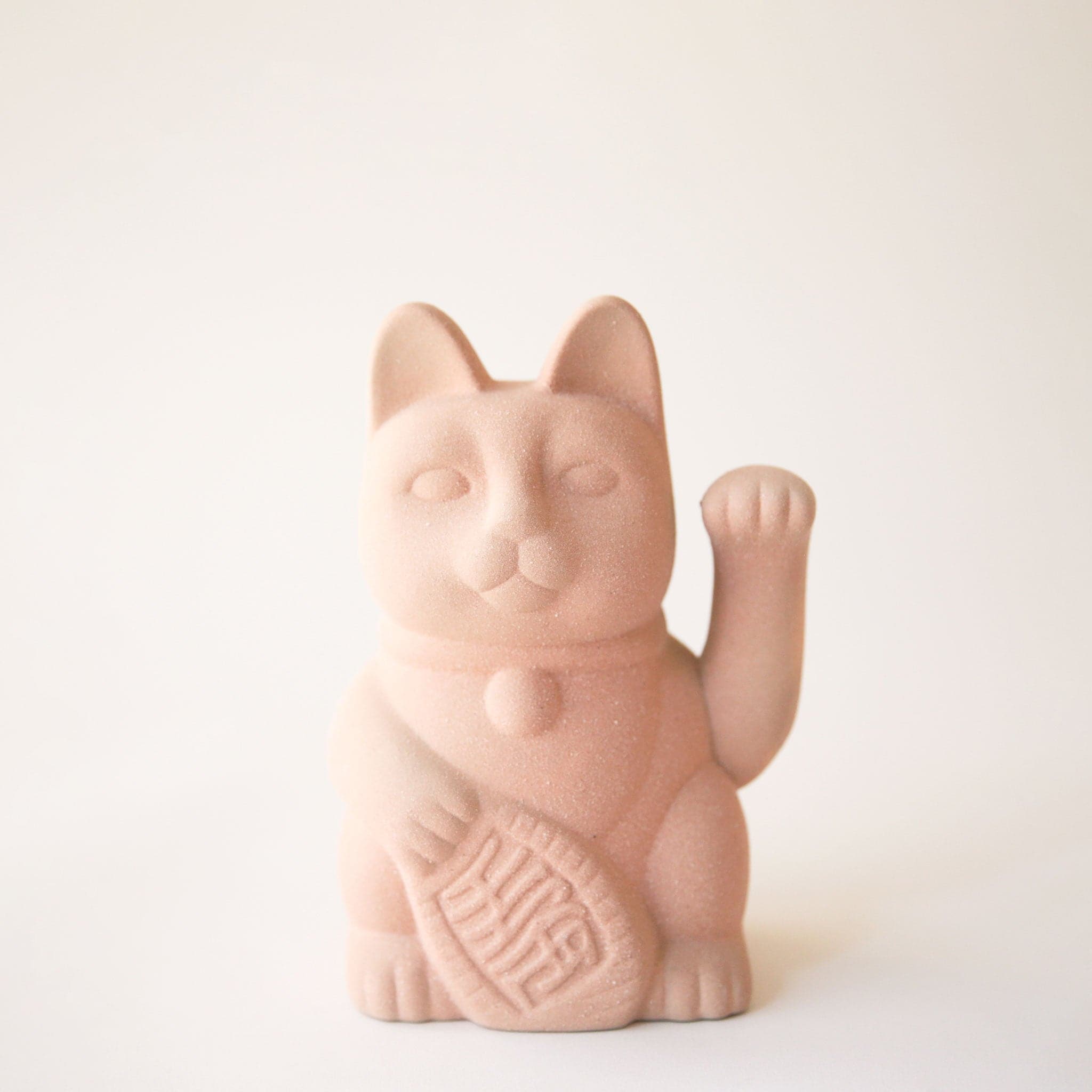 A ceramic lucky cat vase with its paw up in the waving position in a light blush shade.