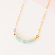 Eight amazonite beads lined up on a gold chain.
