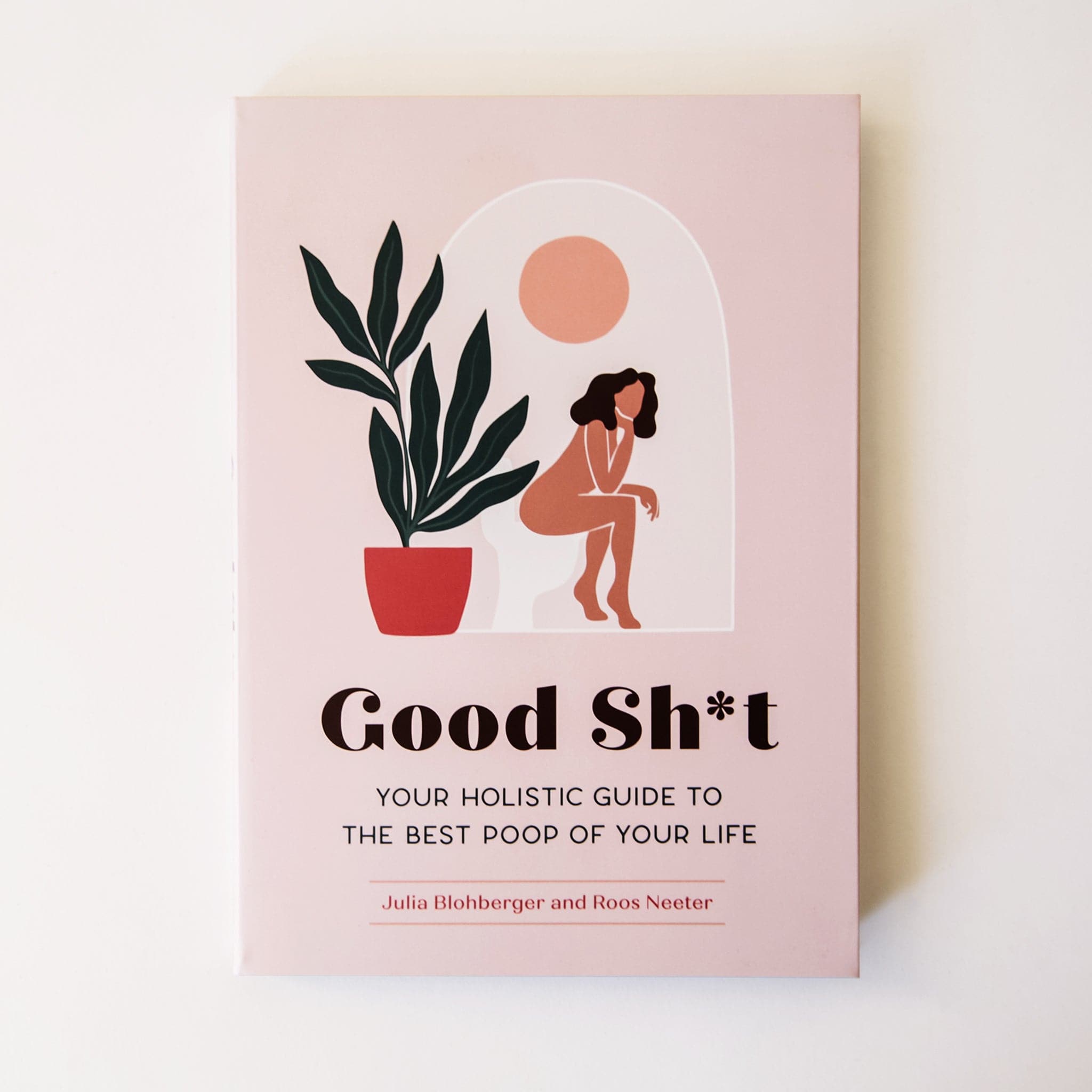 On a cream background is a light pink book with an illustration of someone sitting on a toilet with a plant next to them and the title in black text that reads, &quot;Good Sh*t Your Guide To The Best Poop Of Your Life&quot;.