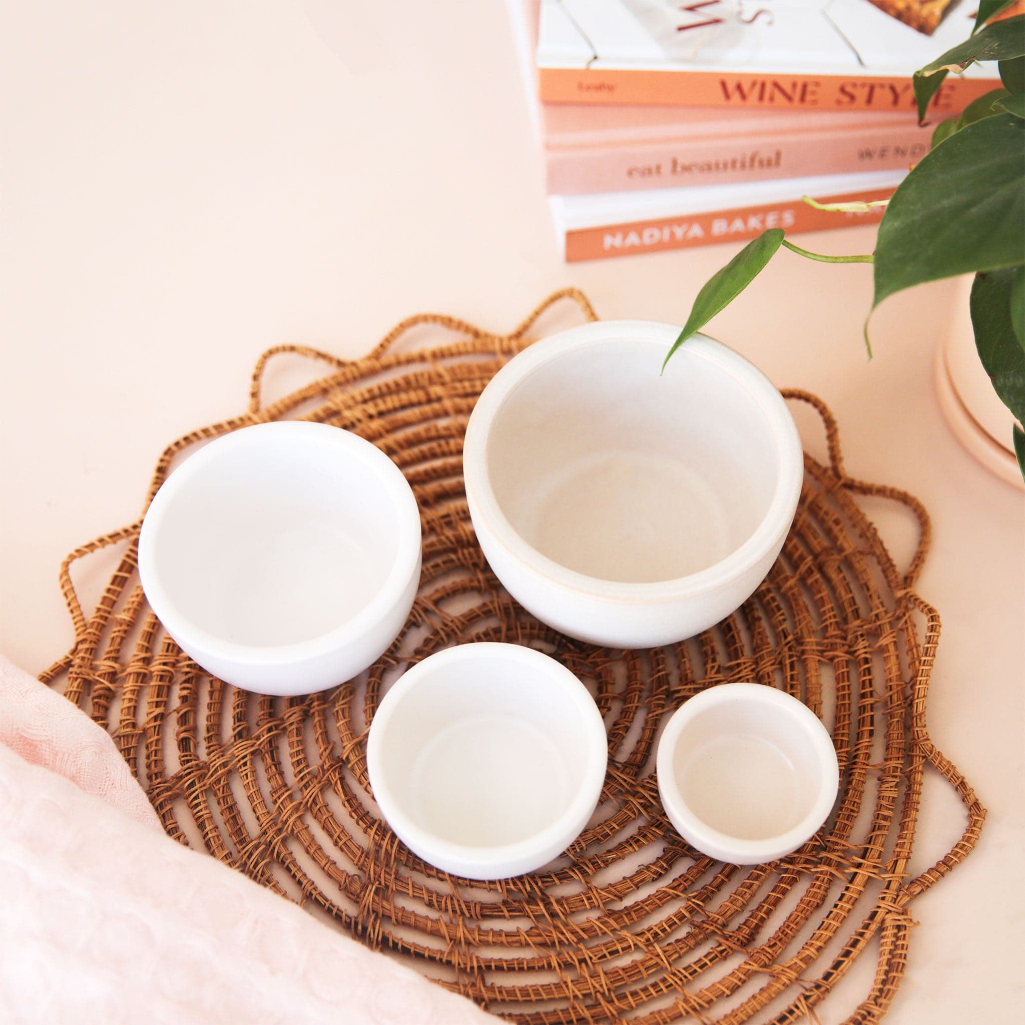 Four white ceramic bowls that nest perfectly inside one another.