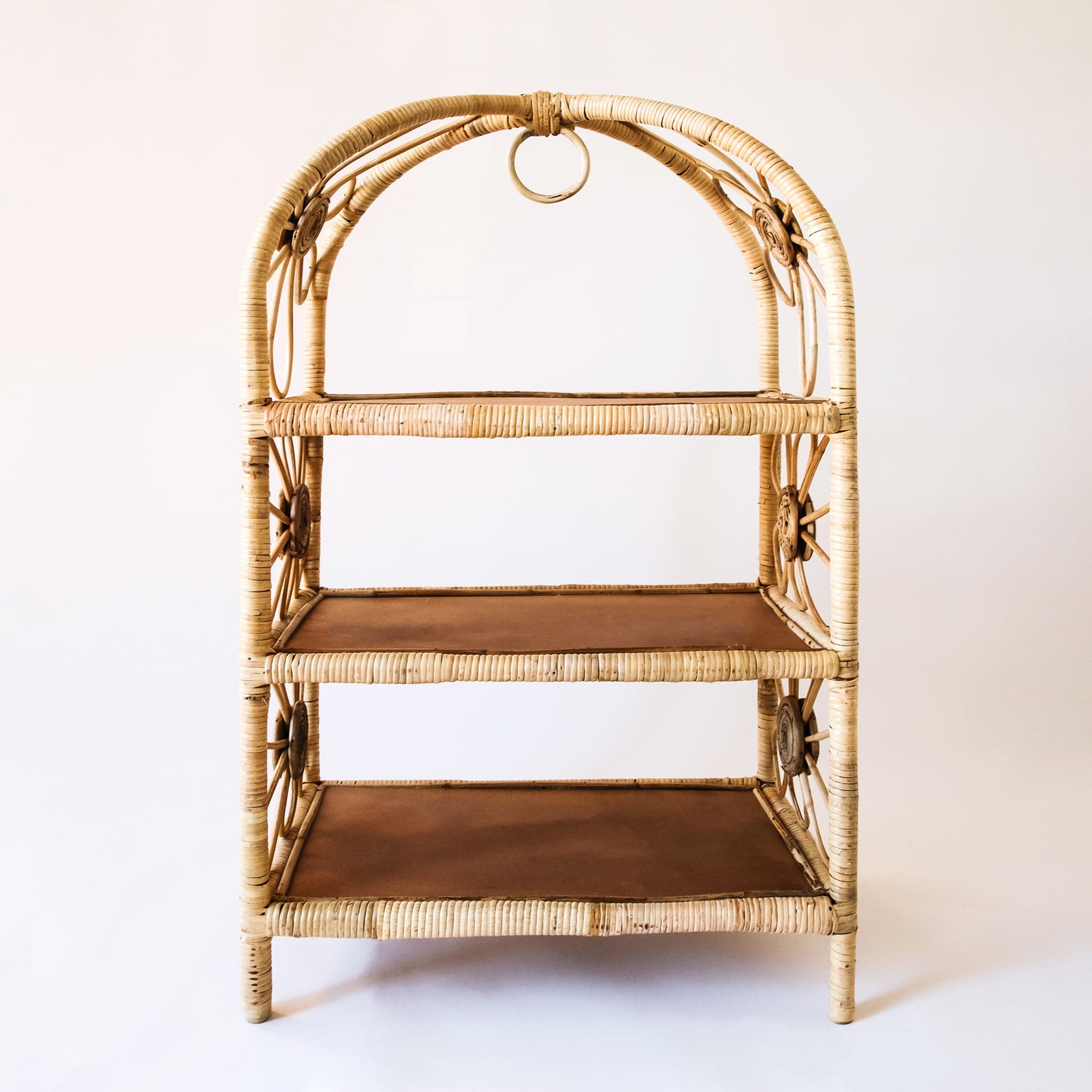 Natural woven rattan shelf with daisy accents on both sides. The sides are open and let in ample light to keep the shelves well lit. Each shelf is covered in rattan and has a chocolate brown bottom.