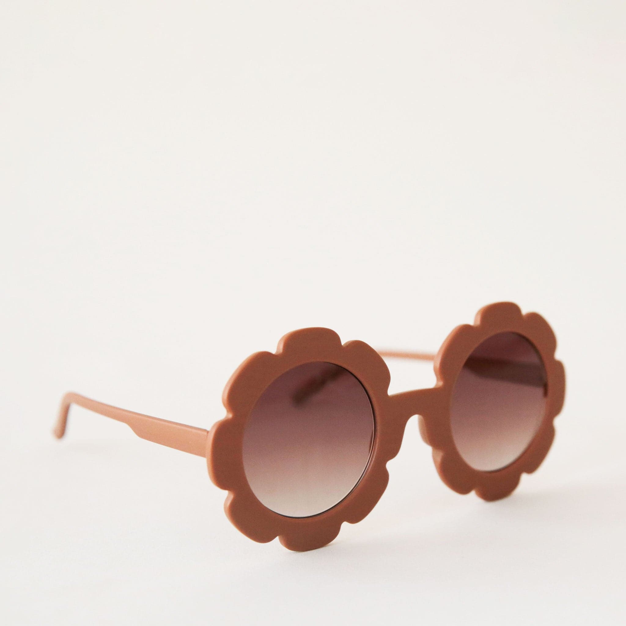 Brown flower shaped sunglasses with light brown circle lenses in the center. 