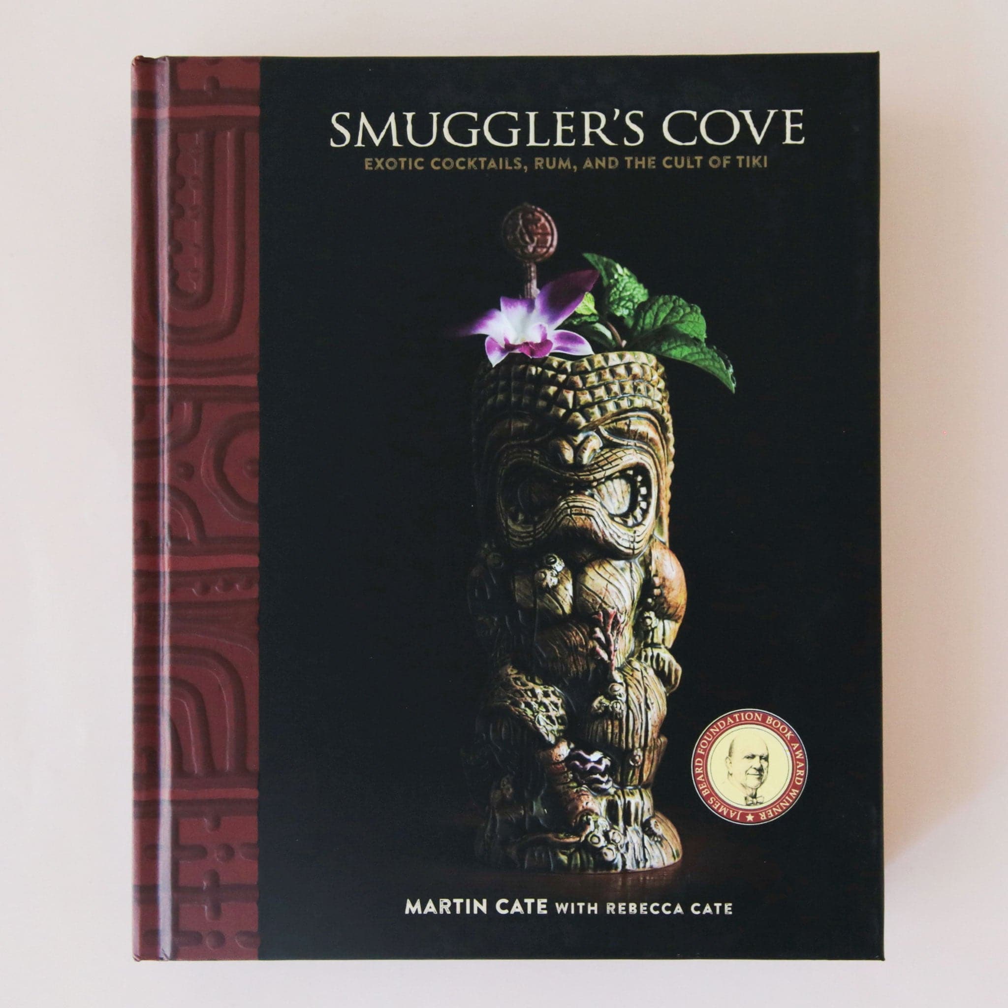  book with a black cover that has a carved tiki on the front along with the title, &quot;Smuggler&#39;s Cove, Exotic Cocktails, Rum and the Cult of Tiki&quot;.