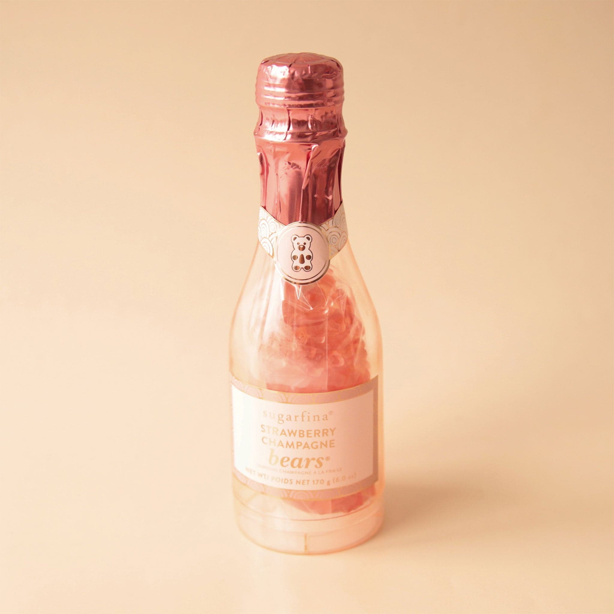 A small plastic champagne bottle filled with Sugarfina&#39;s strawberry champagne gummy bears. 