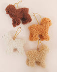 A cream furry poodle ornament with a gold loop for hanging.