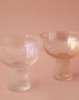 Two iridescent coup glasses with ribbed bases.