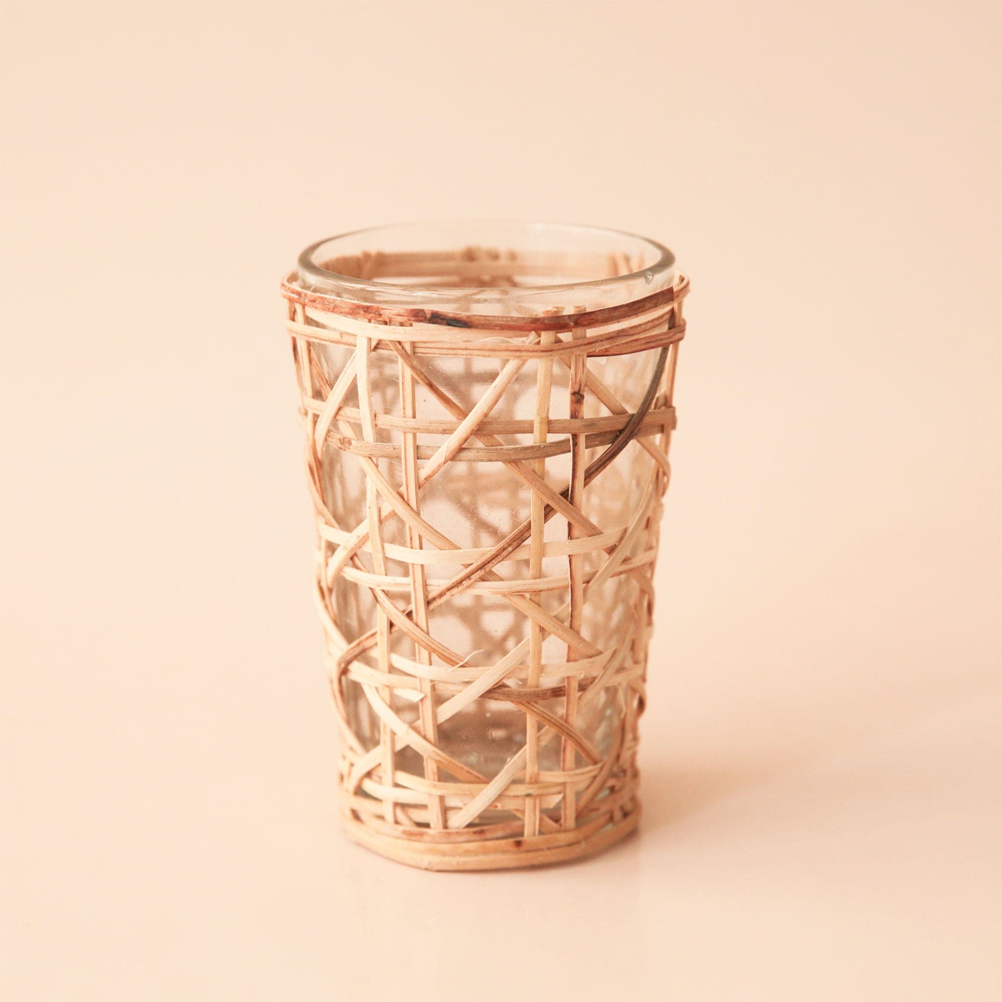 A glass votive with cane webbing detailing.