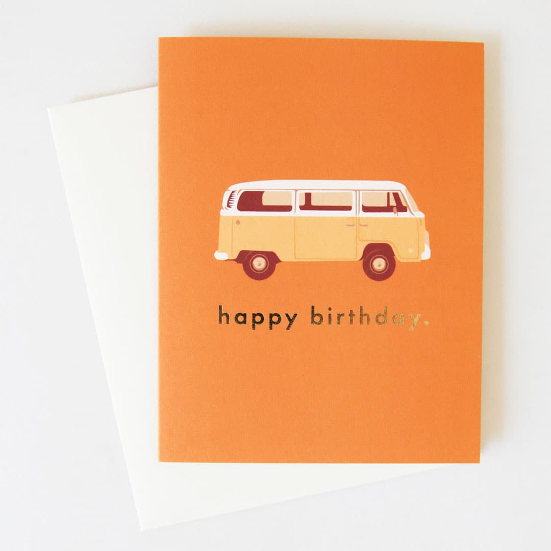 Orange greeting card with illustrated yellow and white Volkswagen van, and "happy birthday" in gold foil. Comes with white envelope.
