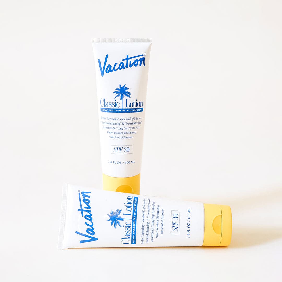 On a white background is a white squeeze tube of sunscreen with a yellow lid and a blue text that reads, "Vacation Classic Lotion SPF 30" along with a blue palm design in the center.