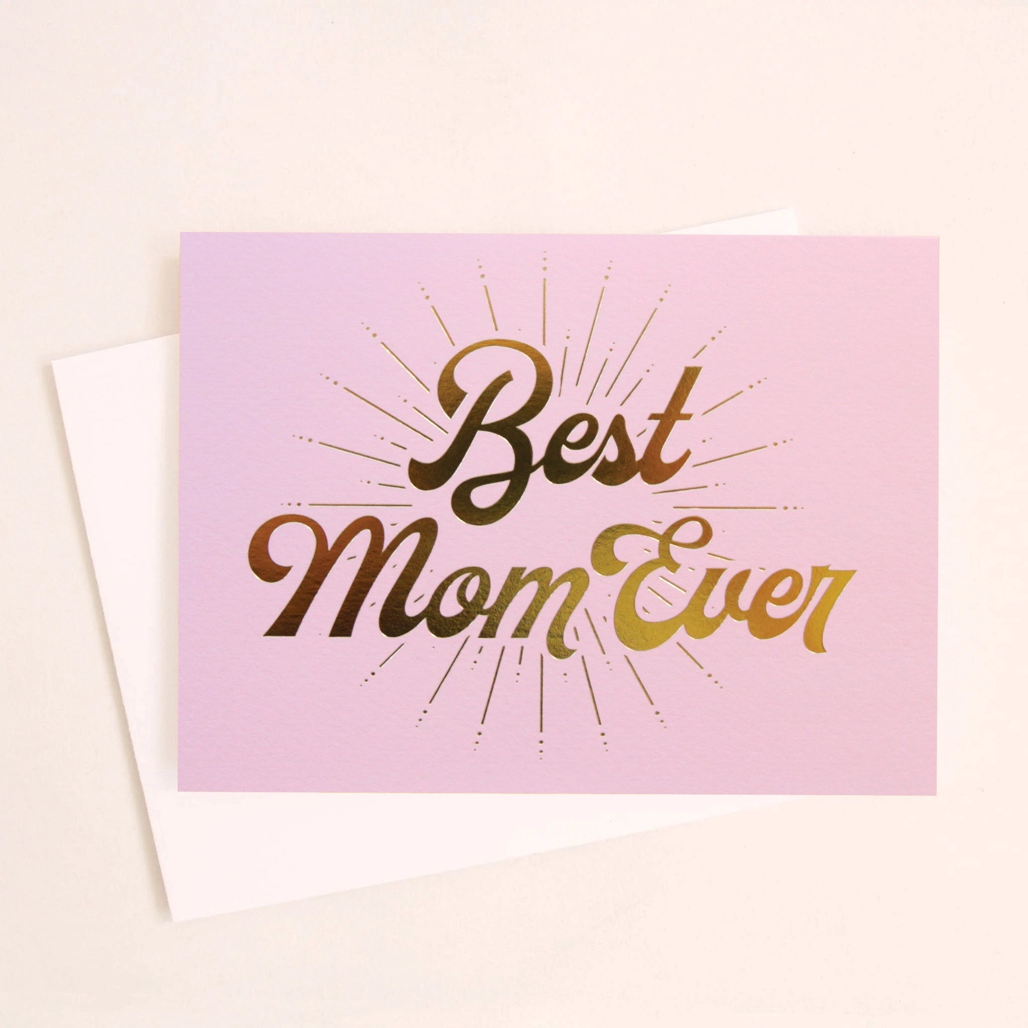 A lilac card with gold foiled letters that read, "Best Mom Ever" along with a white envelope.