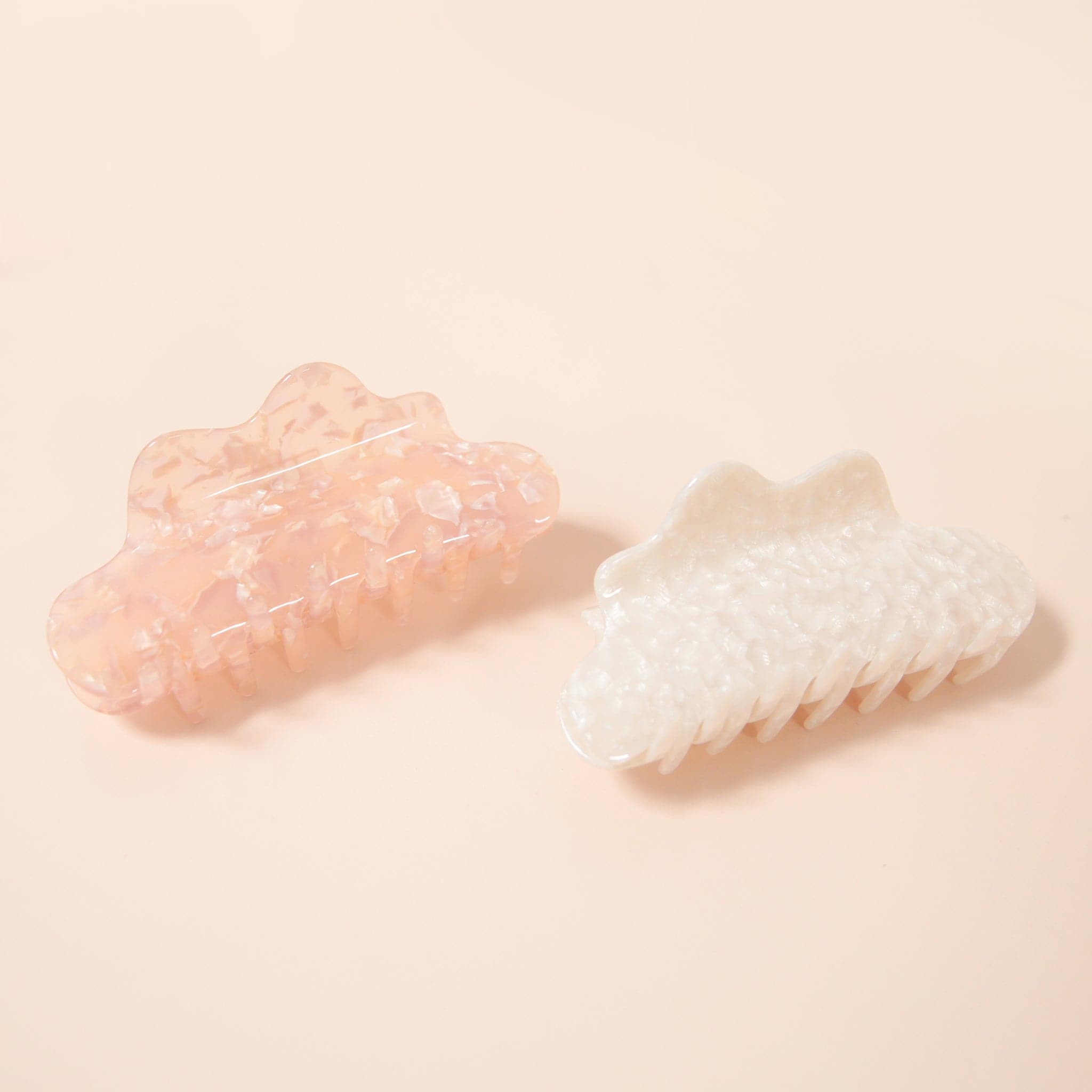 A pink shell-like claw clip with wavy detailing.