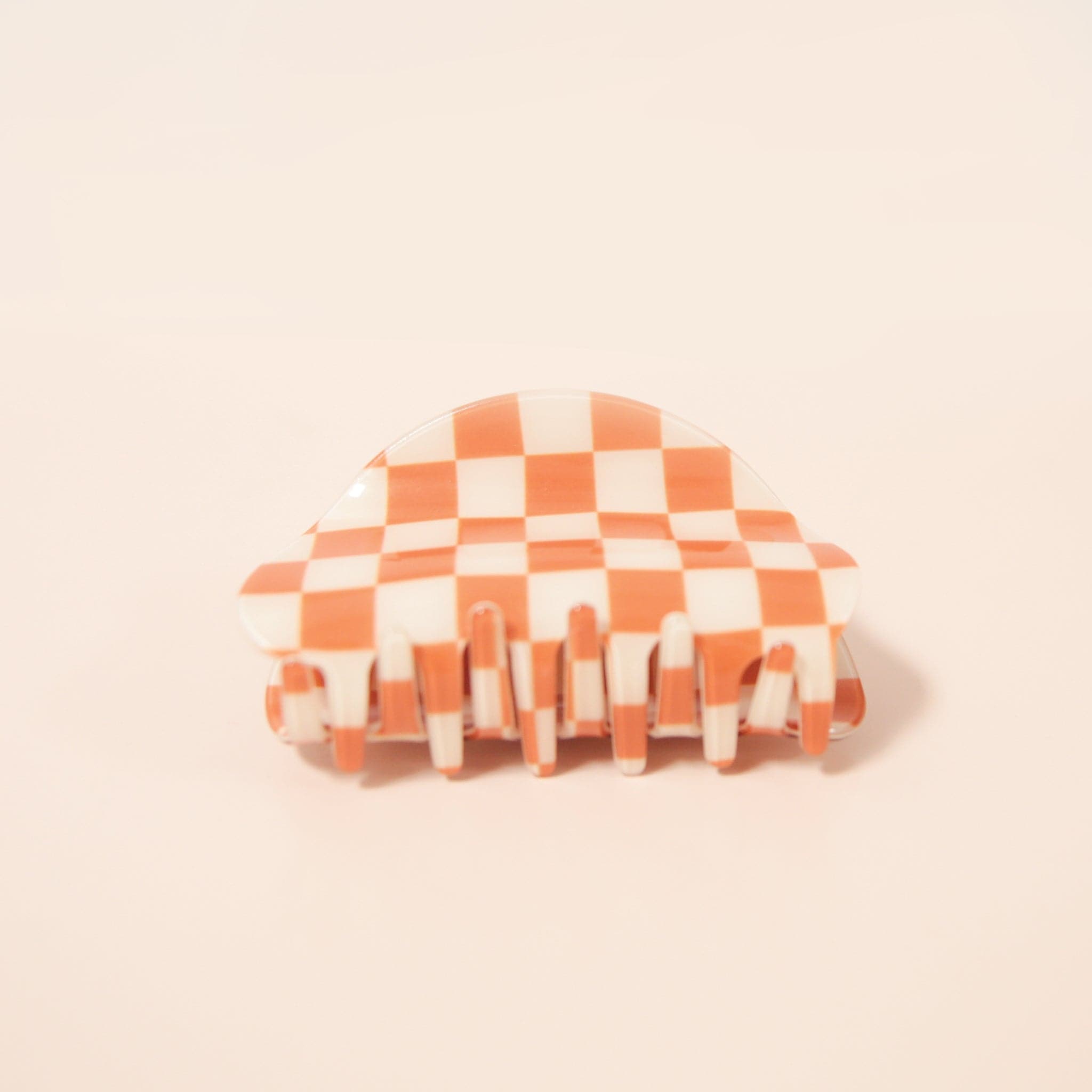 An orange and white claw clip with a rounded edge detail.