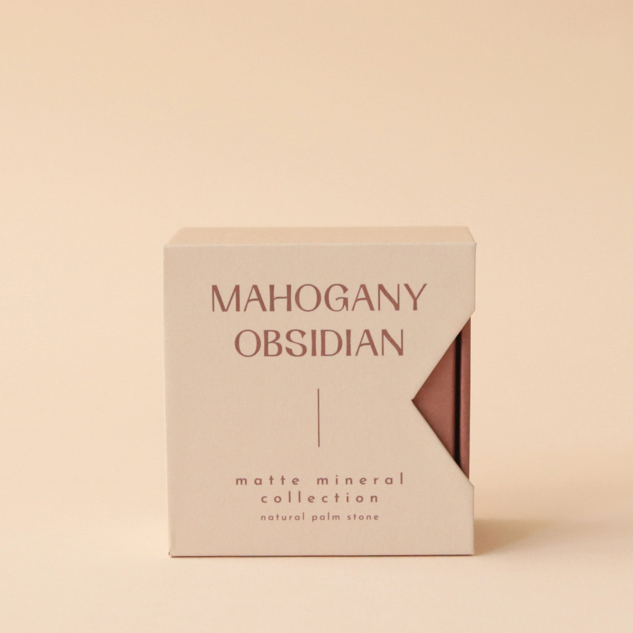 A tan box that reads, &quot;Mahogany Obsidian Matte Mineral Collection&quot; in dark red letters.