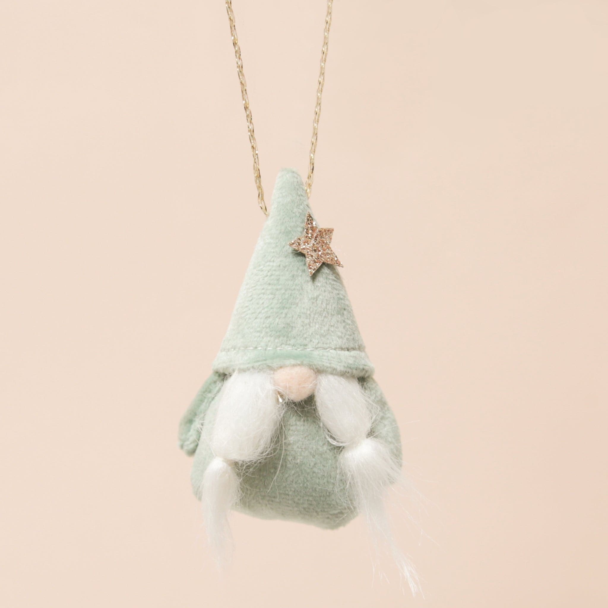 plush mint gnome ornament with a gold star and braided beard on a neutral ground