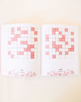 Two open pages filled with sudoku square puzzles. The boxes within the puzzle are blush pink. At the bottom of each page is the number of the puzzle, difficulty level and floral detailing.  