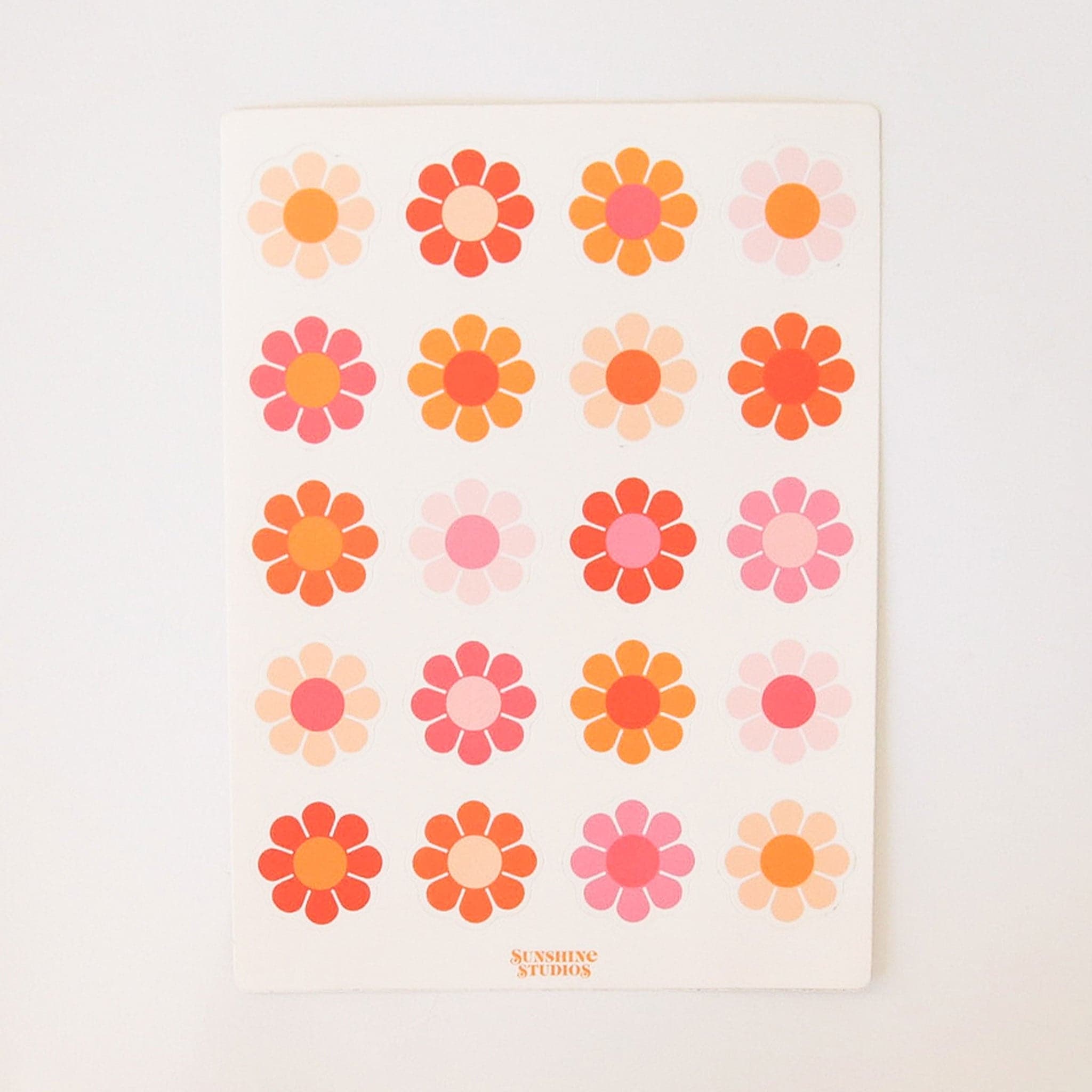 White sticker sheet containing 20 70&#39;s style flowers in various colors of orange, red, pink.