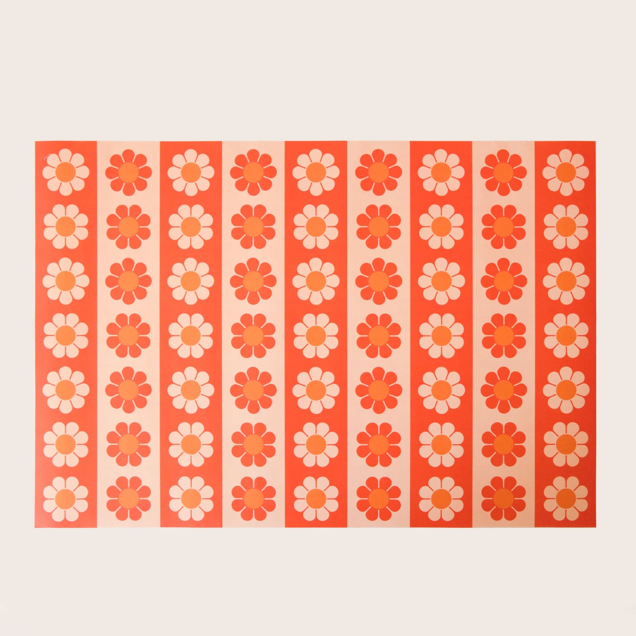 Wrapping paper with an alternating daisy pattern going from light yellow and orange daisies to red and orange. 